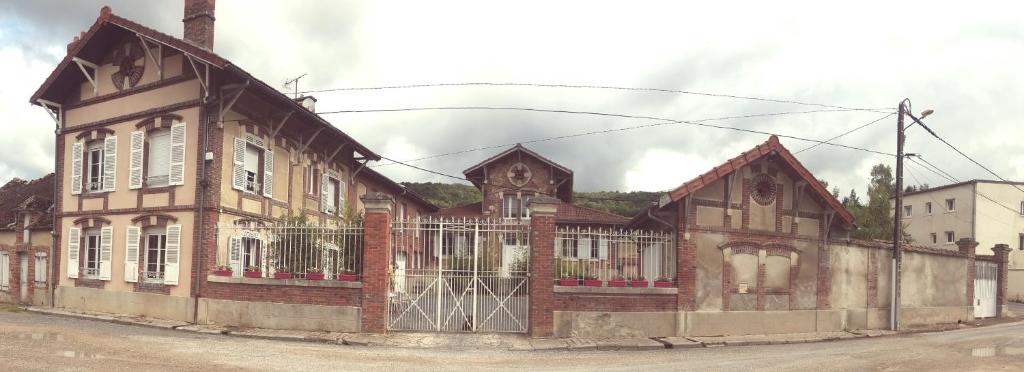 un ancien bâtiment en briques avec une porte dans une rue dans l'établissement Le Gîte De Romane Domaine du vendangeoir, à Vinay