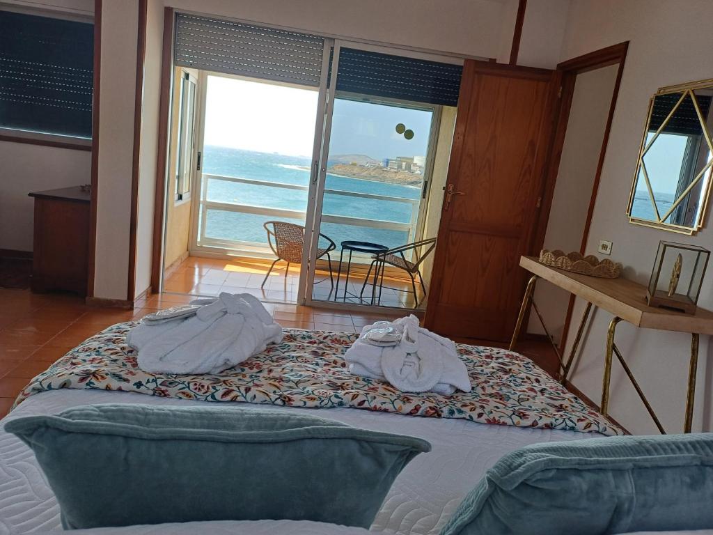 Un dormitorio con dos camas con toallas encima. en Salinetas VISTAMAR, en Telde