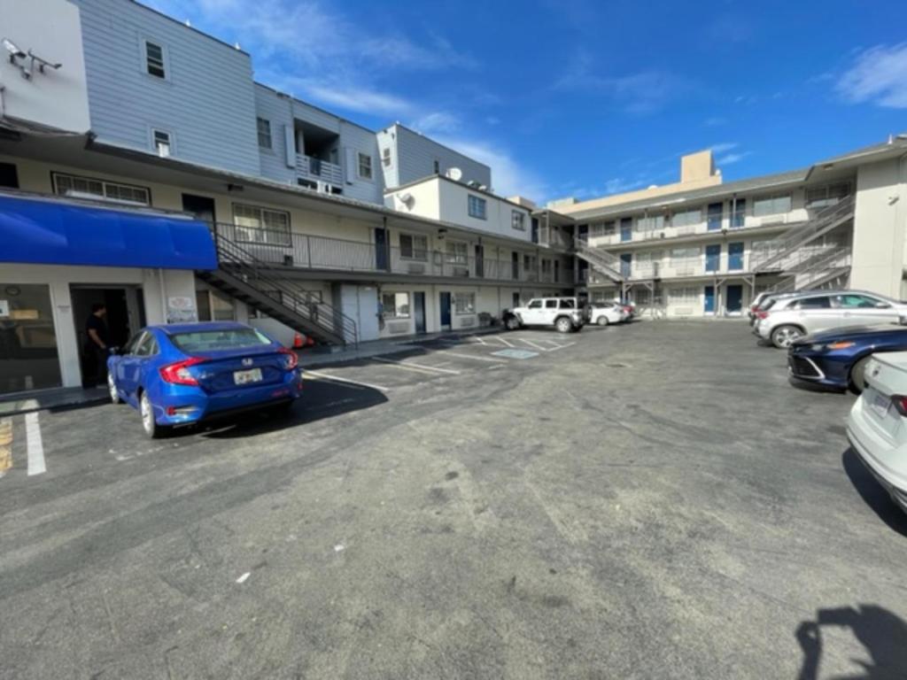 a parking lot with cars parked in front of buildings at Motel 6 San Francisco CA Lombard Street in San Francisco