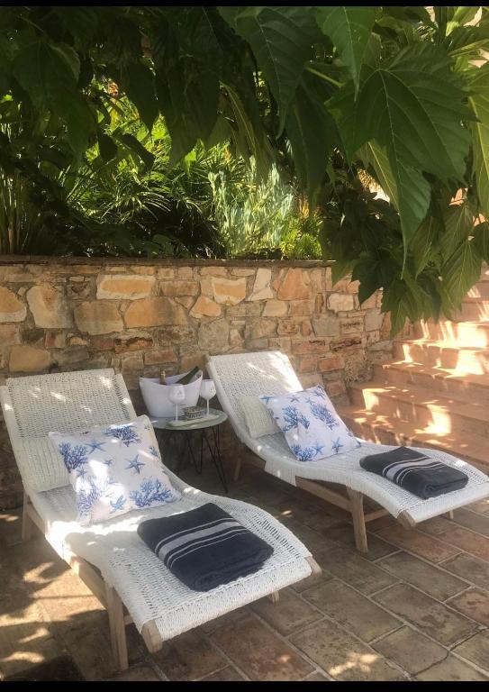 deux chaises en osier blanc avec des coussins bleus et blancs dans l'établissement Le jardin secret de Laura, à Lorgues