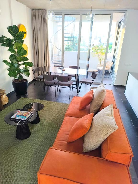a living room with an orange couch and a table at Bridge House 301-3BR Penthouse in Limassol