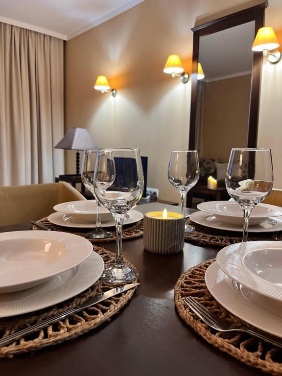 a table with plates and wine glasses on it at SoloApartment in Sunny Beach
