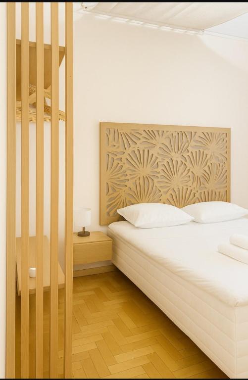 a bedroom with a white bed with a wooden headboard at Athens City Hub in Athens