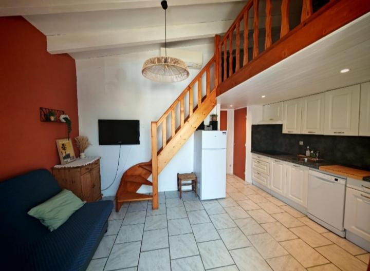 a kitchen with a staircase and a living room at Appartement à 200m de la mer avec place de parking in Le Barcarès