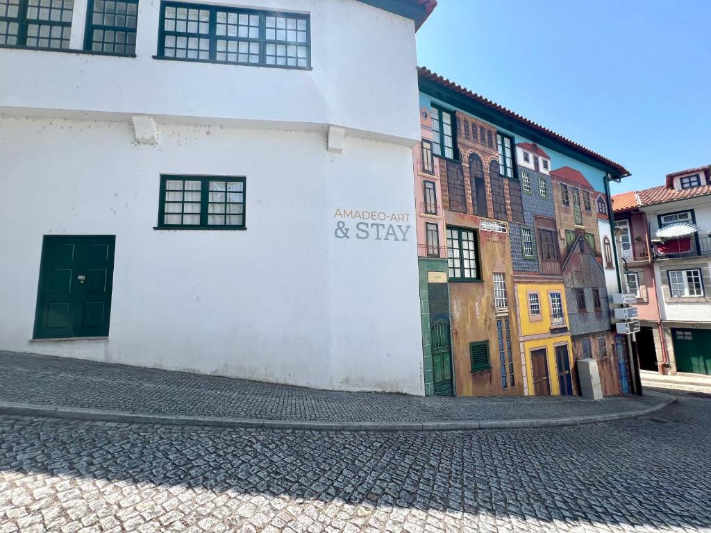 a building with a sign on the side of a street at Amadeo Art&Stay Apartments in Amarante
