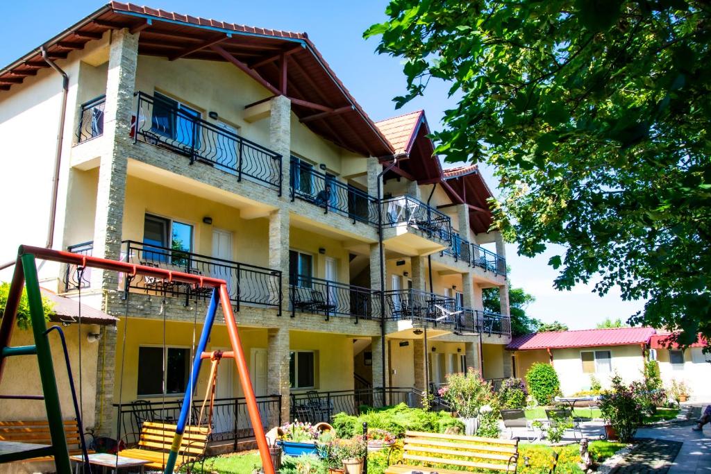 a building with a playground in front of it at Pensiunea Mioara 2 Mai in 2 Mai