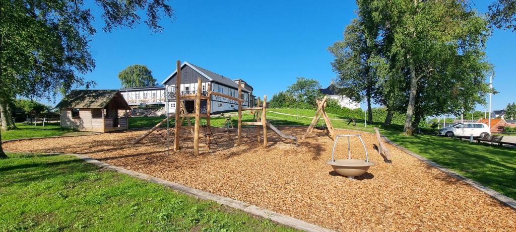 a playground in a yard with a house in the background at Danhostel Rønde in Rønde