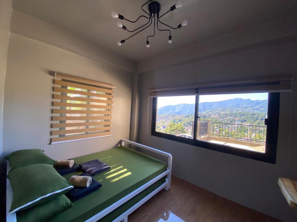 a bedroom with a bed and a large window at Newlives Transient 2 Hillside - 1st Floor in Baguio