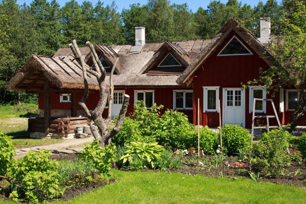 a red house with a garden in front of it at Laugu Holiday Resort in Laugu