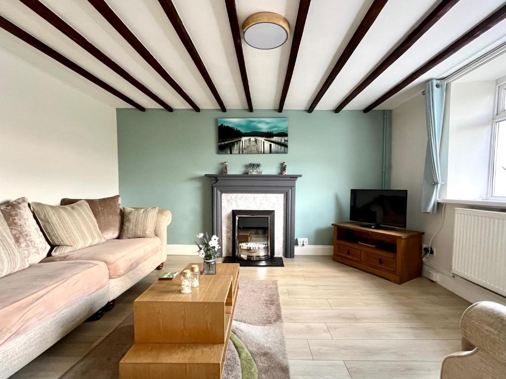 ein Wohnzimmer mit Couch und Kamin in der Unterkunft Miners cottage(1840)Nr. Brecon,Tower Zip & Bike Pk in Aberdare