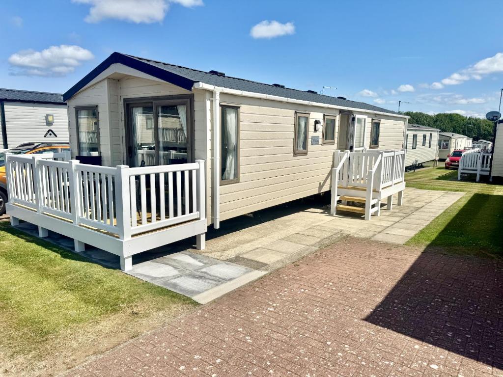 a tiny house with a porch and a deck at North Bay Leisure Park in Bridlington
