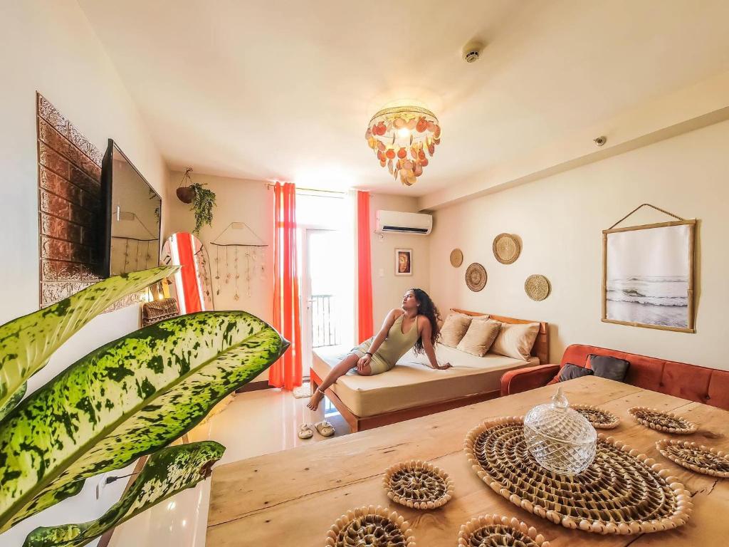 une femme assise sur un canapé dans un salon dans l'établissement Tropical Studio 40mbps, à Lapu Lapu City