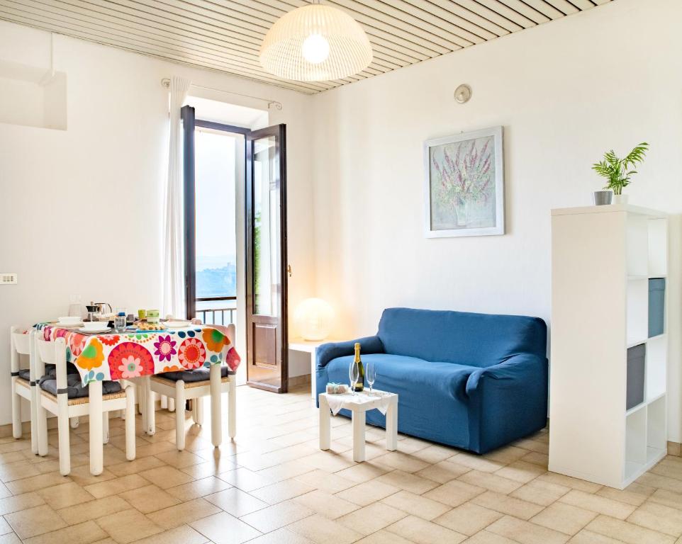 a living room with a blue couch and a table at Casa Lina - Apartment with lake view in Dagnente