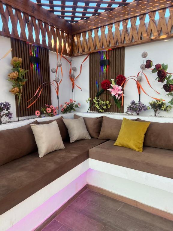 a couch in a room with flowers on the wall at Villa vacances proximité plage in Taguermess