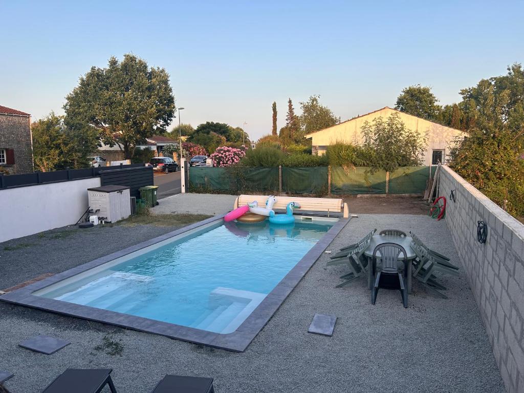 une piscine avec deux bateaux dans une cour arrière dans l'établissement Maison à Oléron avec piscine chauffée et privée, à Dolus-d'Oléron