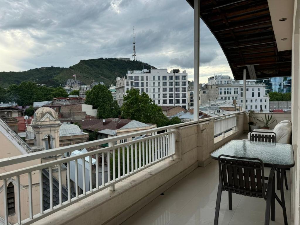 a balcony with a table and a view of a city at Terrace NANA in Tbilisi City