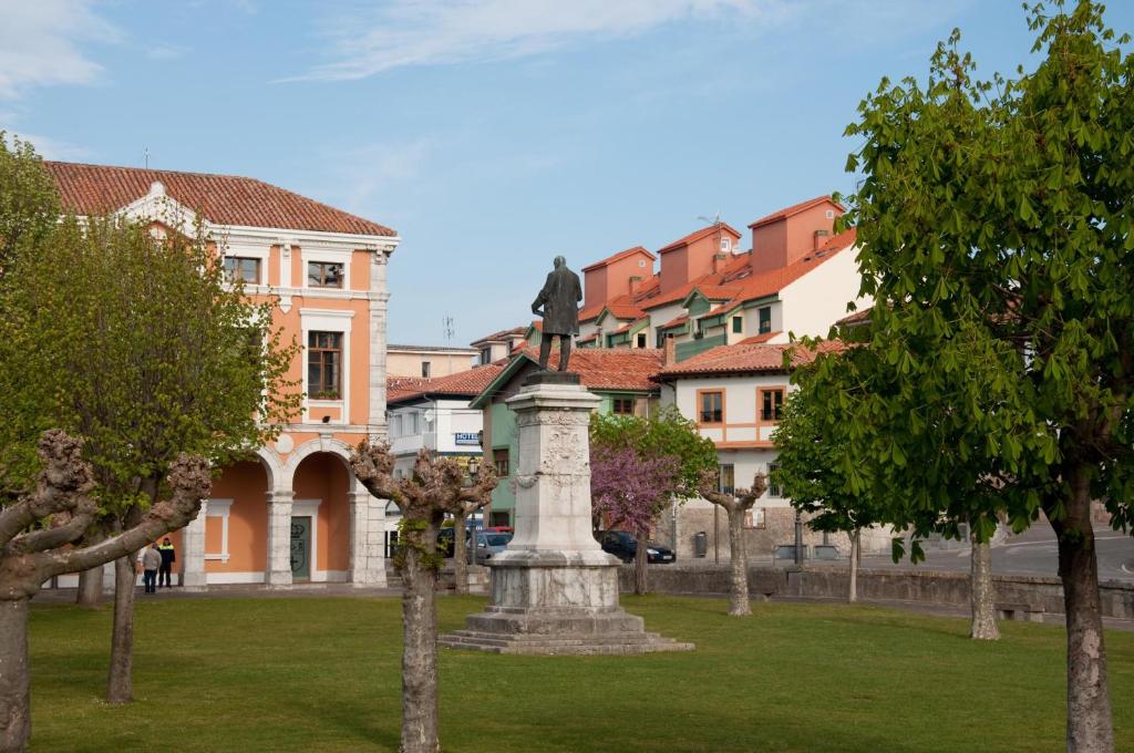 una estatua en un parque con edificios en el fondo en Casa Montse-Izquierda, en Colombres