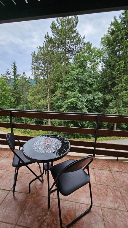 a patio with a table and two chairs on a porch at MALA KUĆA, Lič in Lič