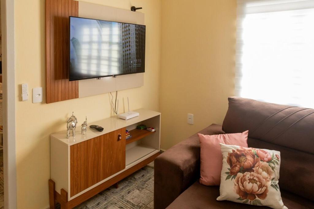 a living room with a couch and a flat screen tv at Casa Centro de Guabiruba in Guabiruba