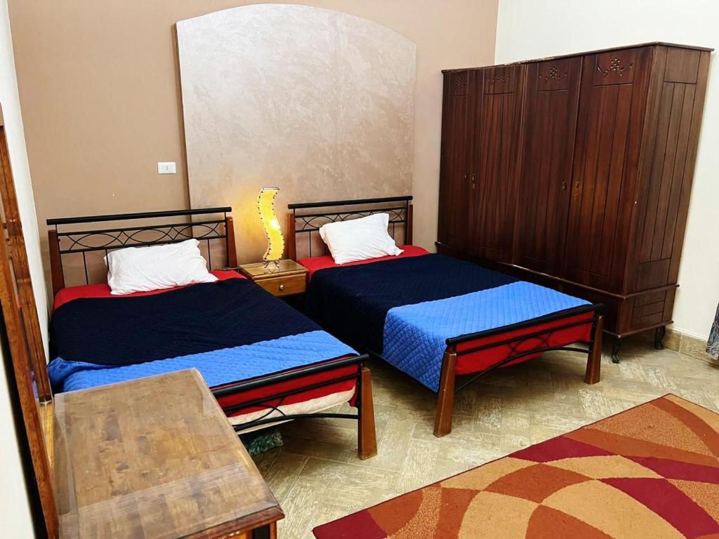 a bedroom with two beds and a chair and a table at Villa at Marassi in El Alamein