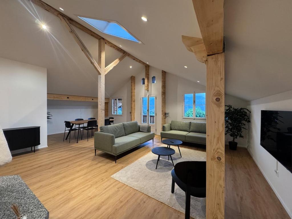 a living room with a couch and a table at Des Alpes Sky Apartment in Beatenberg