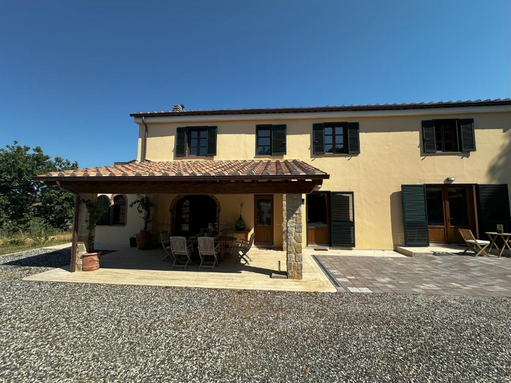 ein großes Haus mit einer Terrasse davor in der Unterkunft Villa La Cava in Riparbella