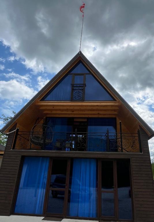 a house with a balcony on top of it at RIVERSIDE Cottage in Martvili