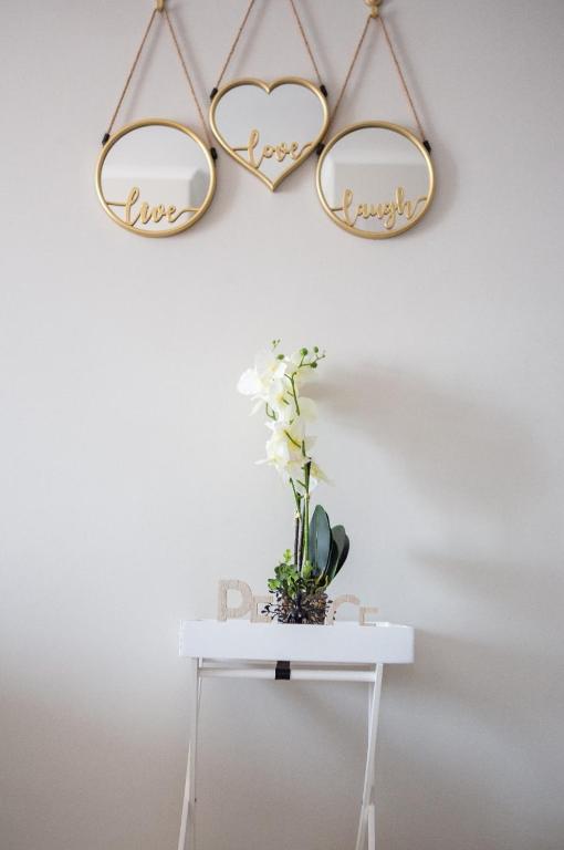 two heart shaped mirrors hanging on a wall with a table at Oasis Comfort Apartment in Midrand