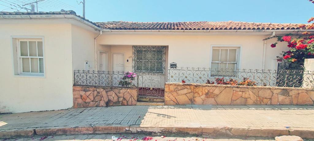 a white house with a stone fence and a gate at Casa 420 in Diamantina
