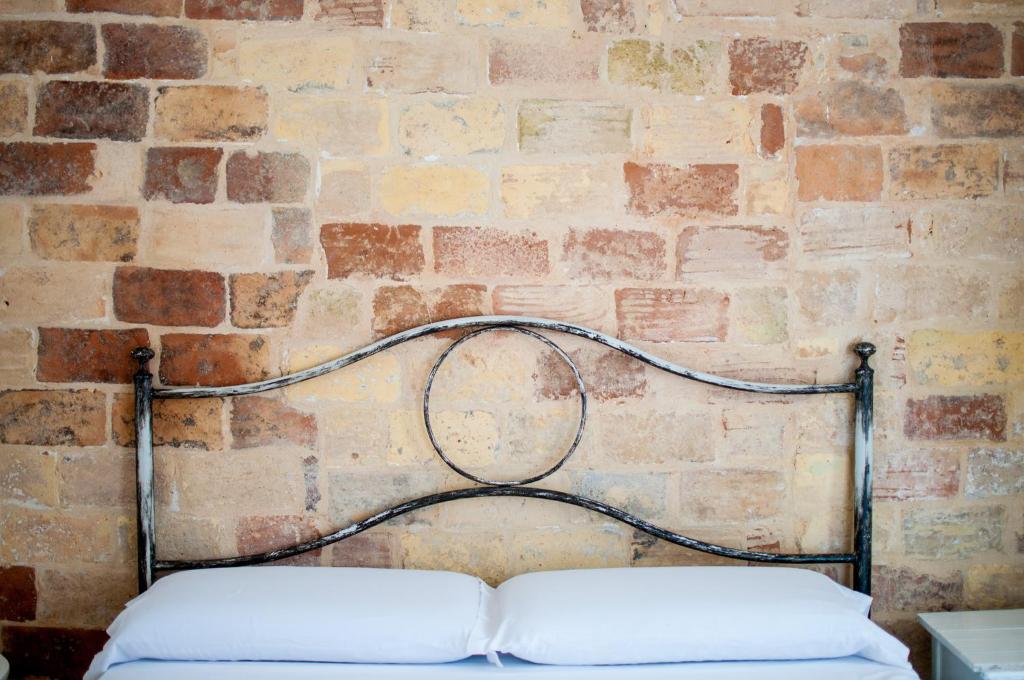 a brick wall with a bed in front at Corte Santa Maria B&B in Vasto