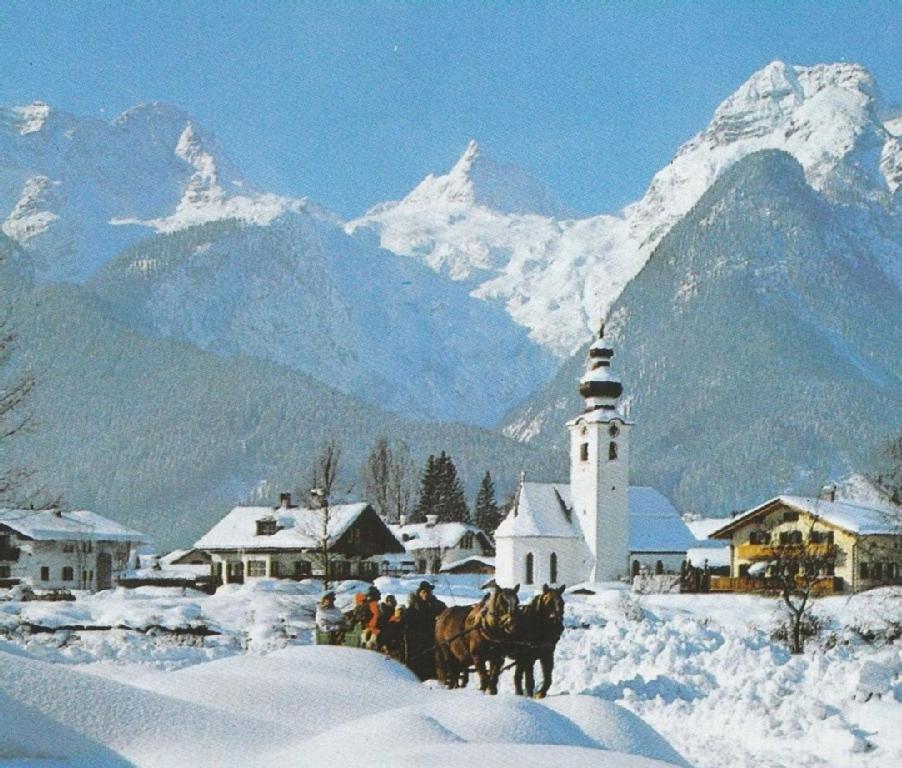 Eine Gruppe von Menschen auf Pferden im Schnee mit einem Leuchtturm in der Unterkunft Fewo Schlosspark Grubhof in Sankt Martin bei Lofer