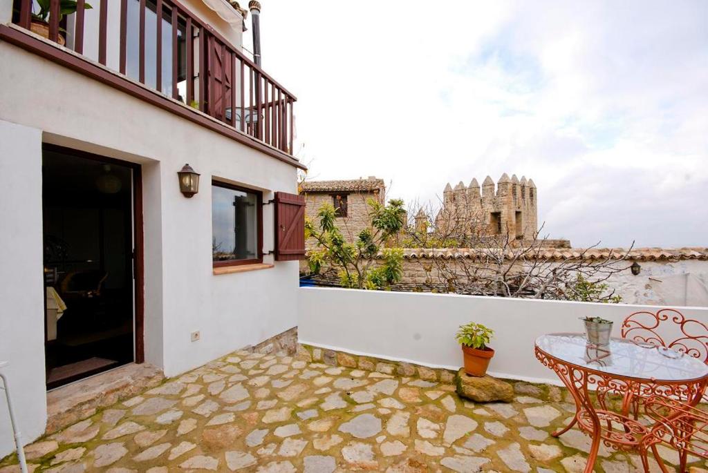 einen Balkon mit einem Tisch und Blick auf ein Schloss in der Unterkunft La Casa Escondida in Sabiote