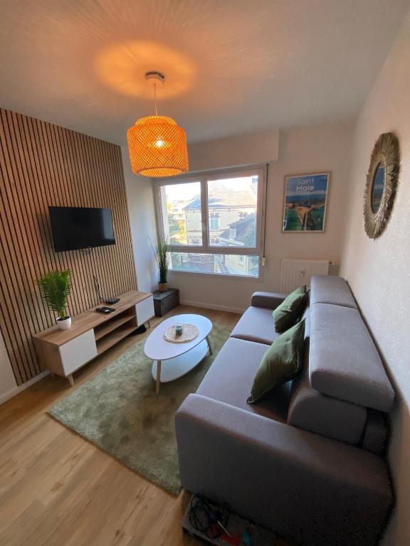 a living room with a couch and a table at Les Quais centre-ville in Rennes