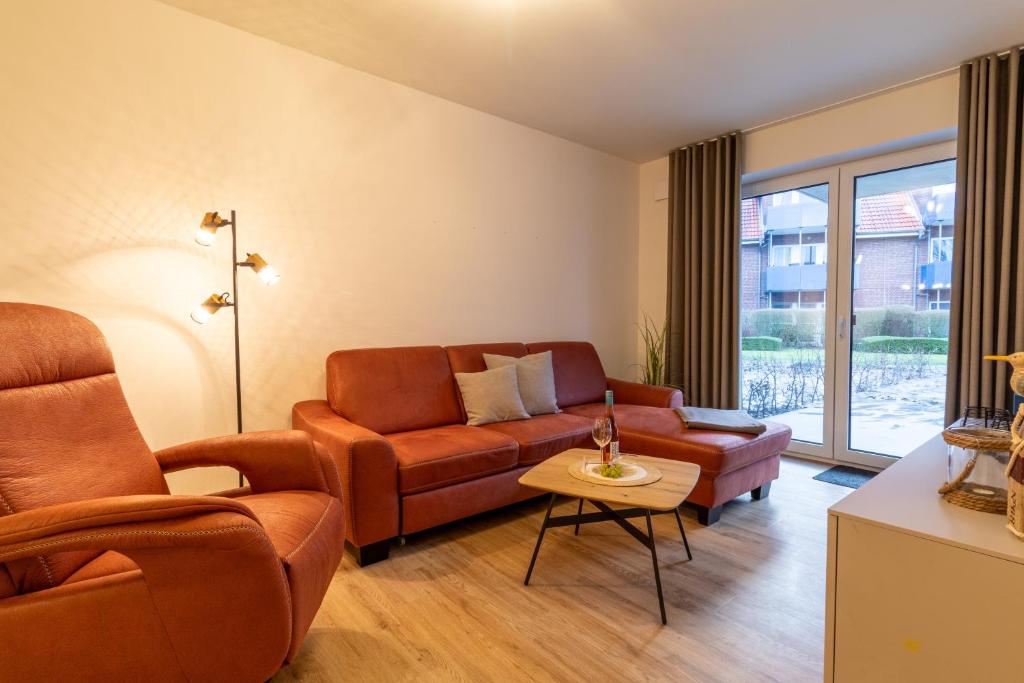 a living room with a couch and a chair at Dorumer Sielhuus 7 - Ferienwohnung mit Terrasse und Sauna in Dorum