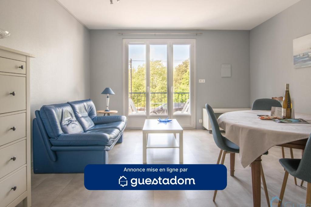 un salon avec une chaise bleue et une table dans l'établissement L'Air Marin - 300m de la plage - Parking, à Pornic