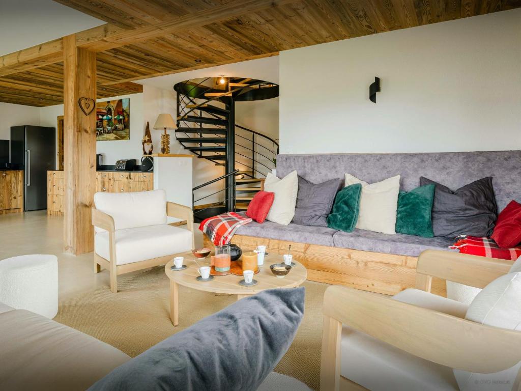 a living room with a couch with colorful pillows at Chalet Paralpin - OVO Network in Manigod