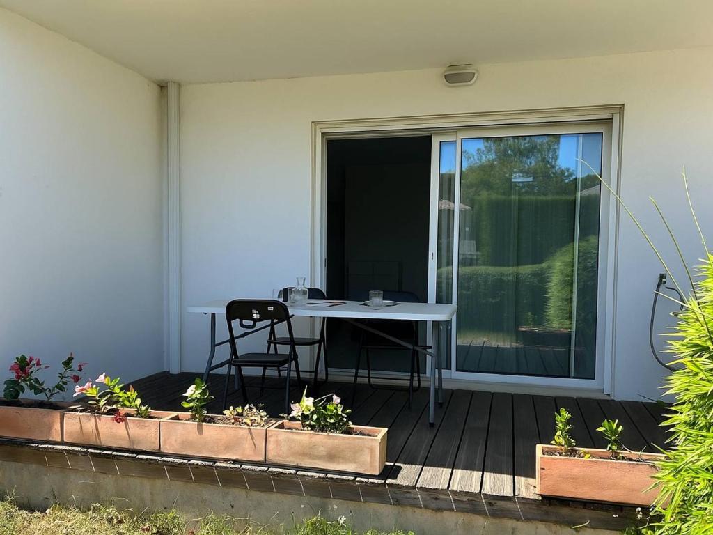 un patio avec une table et des chaises sur une terrasse dans l'établissement Appartement T3 cosy avec jardin à deux pas du centre de Meschers, garage et animaux admis - FR-1-738-1, à Meschers-sur-Gironde