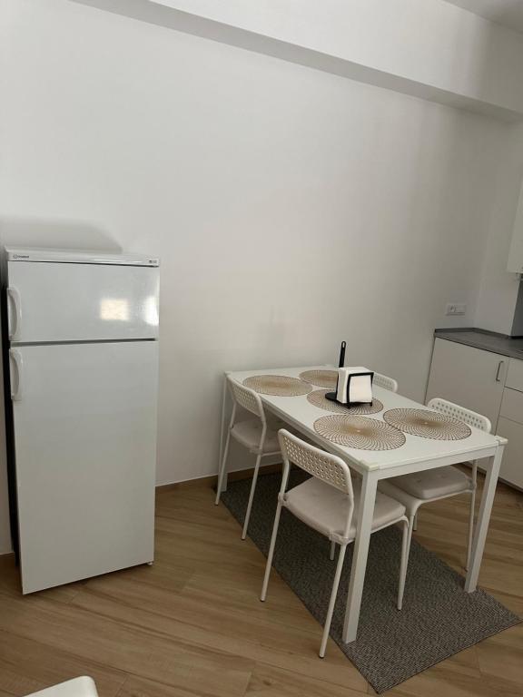 a kitchen with a white table and chairs and a refrigerator at Monte Roraima in Scalea