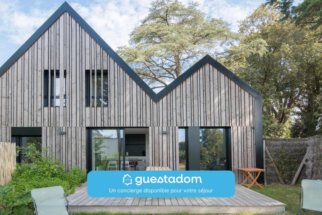 a timber house with a black roof at Sekoya Lodge - Proche plage - golf in Pornic