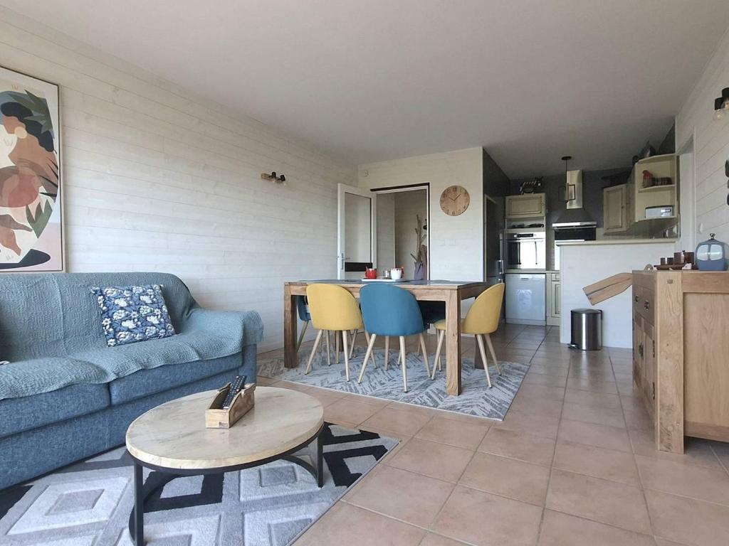 un salon avec un canapé bleu et une table dans l'établissement Appartement rénové 3 pièces avec terrasse, casier à skis et parking privé à Bolquère - FR-1-592-40, à Bolquère-Pyrénées 2000