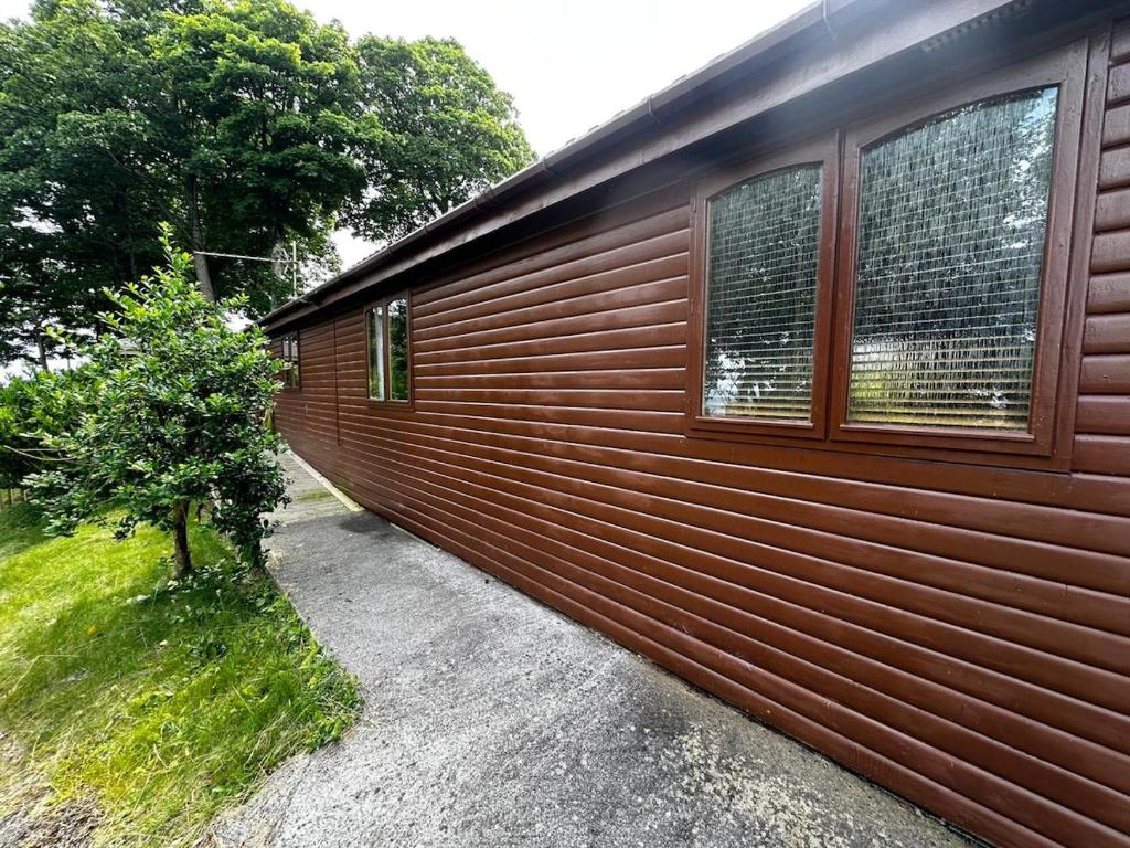 a wooden wall with windows on the side of a house at The Retreat in Berrynarbor