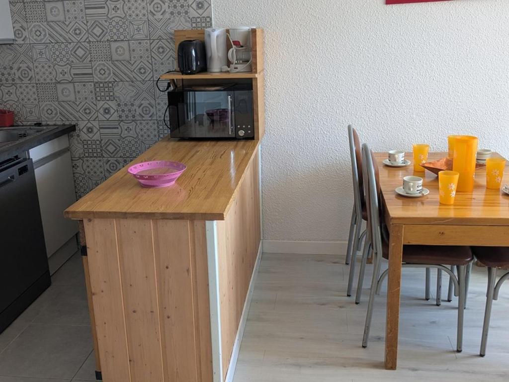une cuisine avec un comptoir en bois et une table avec des chaises dans l'établissement Maxi Studio pour 4 pers, Expo SUD, au Centre d'Orcières Merlette, Proche Pistes et Commerces - FR-1-262-102, à Forest des Baniols