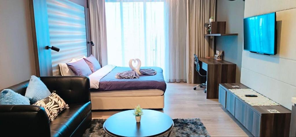 a living room with a couch and a tv at CozyNest Suites Bukit Bintang in Kuala Lumpur