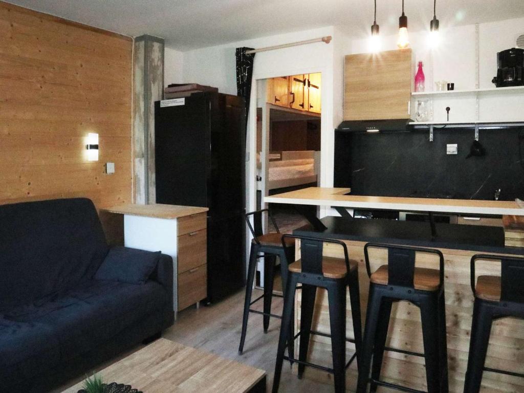 un salon avec un canapé et une cuisine avec une table dans l'établissement Joli studio rénové, 4 pers, skis aux pieds, balcon, lave-linge, sèche-linge, animaux admis - FR-1-322-523, aux Orres