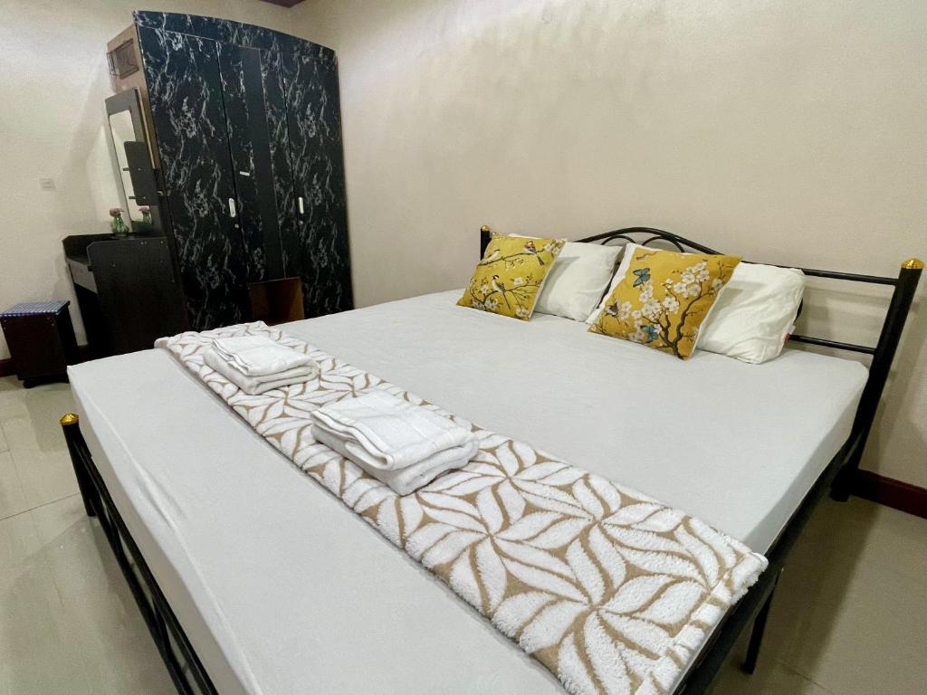 a bed with white sheets and pillows on it at Yoga Bed and Breakfast in Chiang Mai