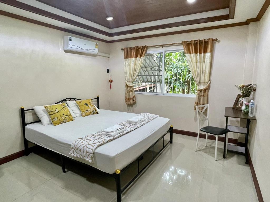 a bedroom with a bed and a window at Yoga Bed and Breakfast in Chiang Mai