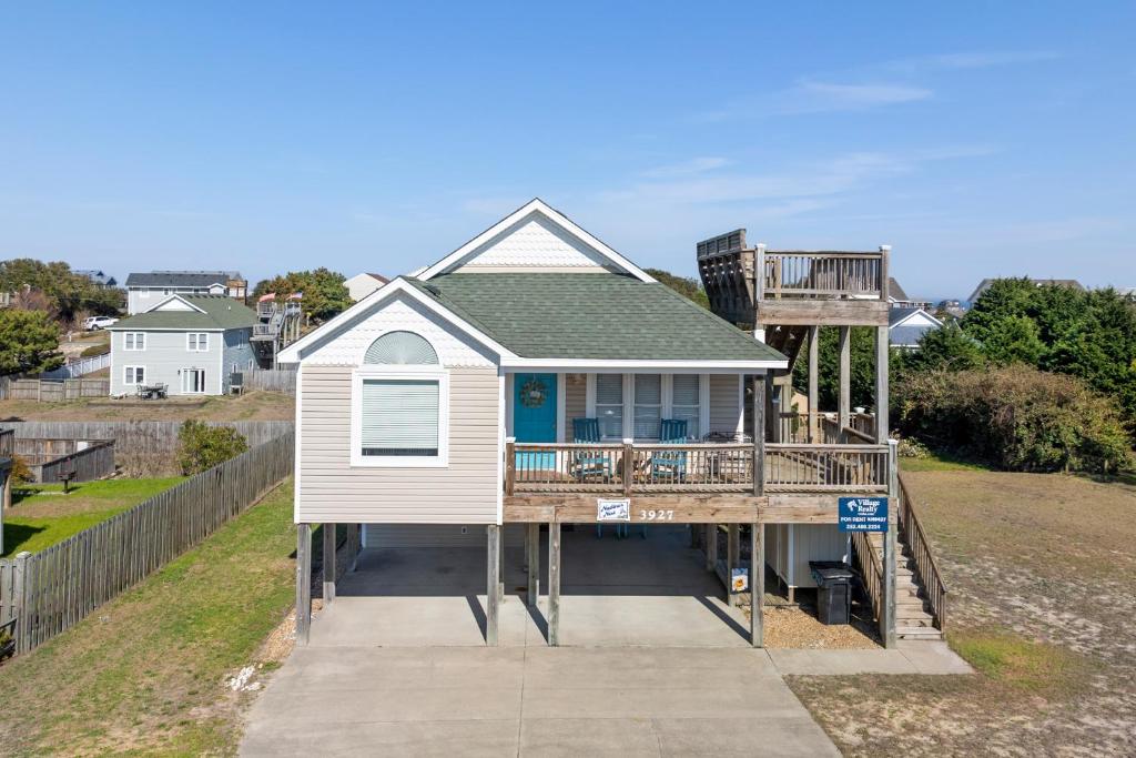 een huis aan een dok met een veranda en een terras bij Nadines Nest in Kitty Hawk