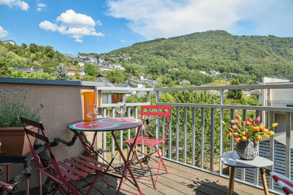 un patio avec une table et des chaises sur un balcon dans l'établissement Le Millesime - Barby, à Barby