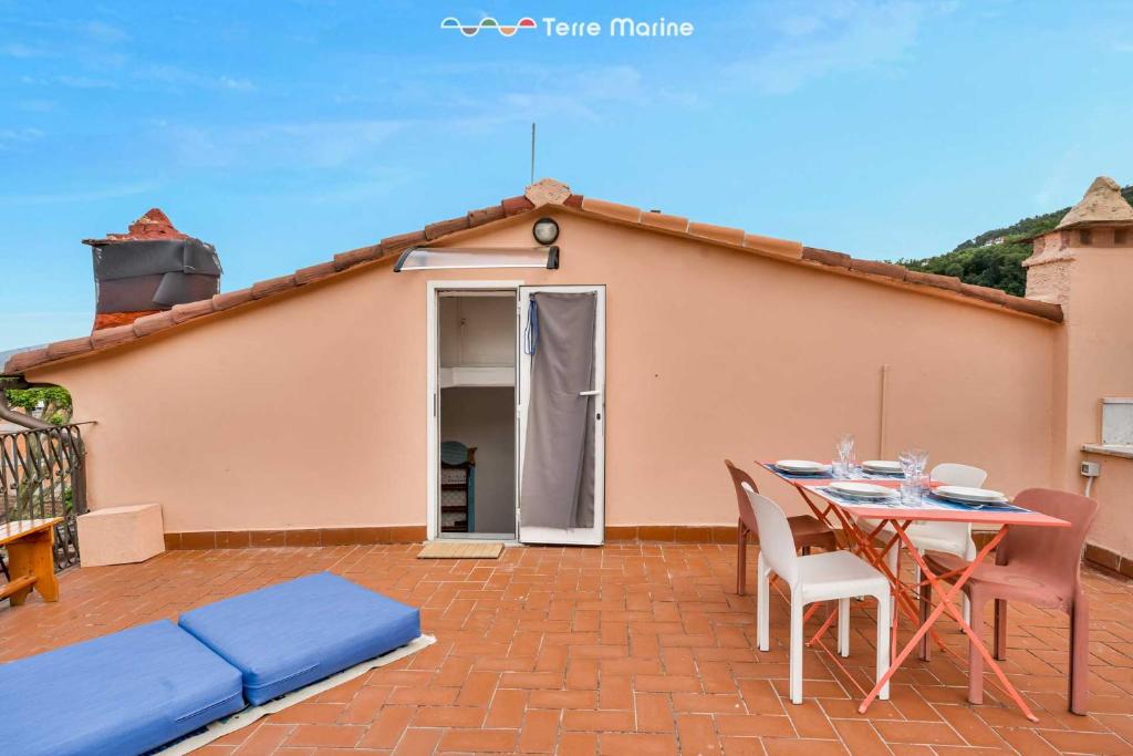 een terras met een tafel en stoelen voor een huis bij La Goletta, Terre Marine in La Spezia