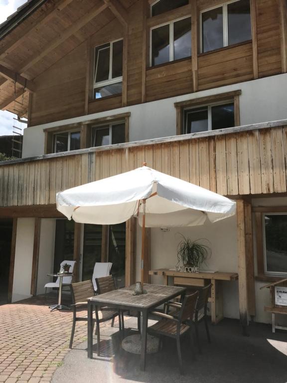 a table with an umbrella on a patio at 2-Zimmer Ferienwohnung,Parterre,Sitzplatz,Garage in Adelboden